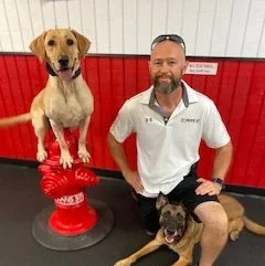wes - trainer and owner posing with two dogs